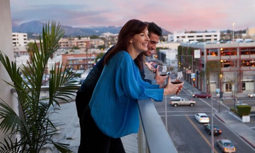 a couple drinking wine on a balcony
